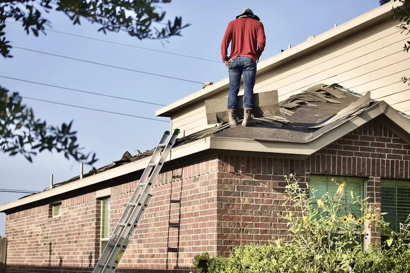 Professional roofer working on a residential roof in Lower Greenville